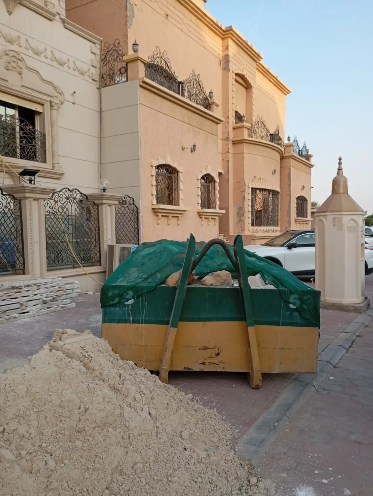 حاوية أنقاض مغطاة بالشبك أمام منزل